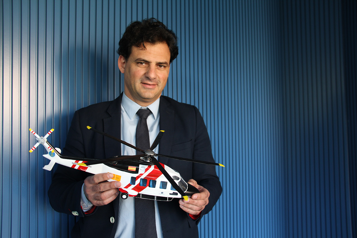 Hombre sonriente sujetando una maqueta de helicóptero de salvamento marítimo