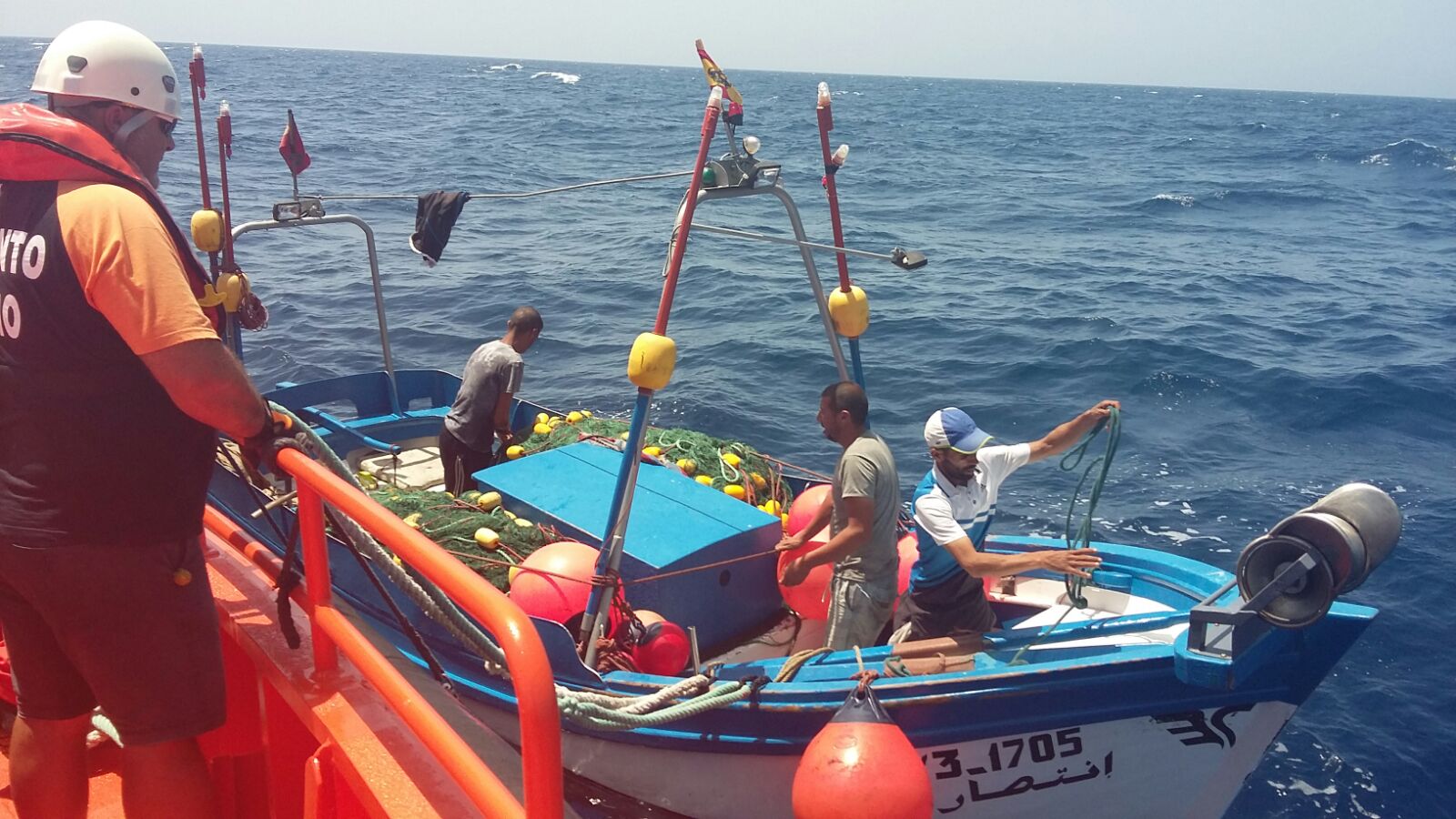 Tripulante de sasemar desde su embarcación mirando al pesquero y su tripulación