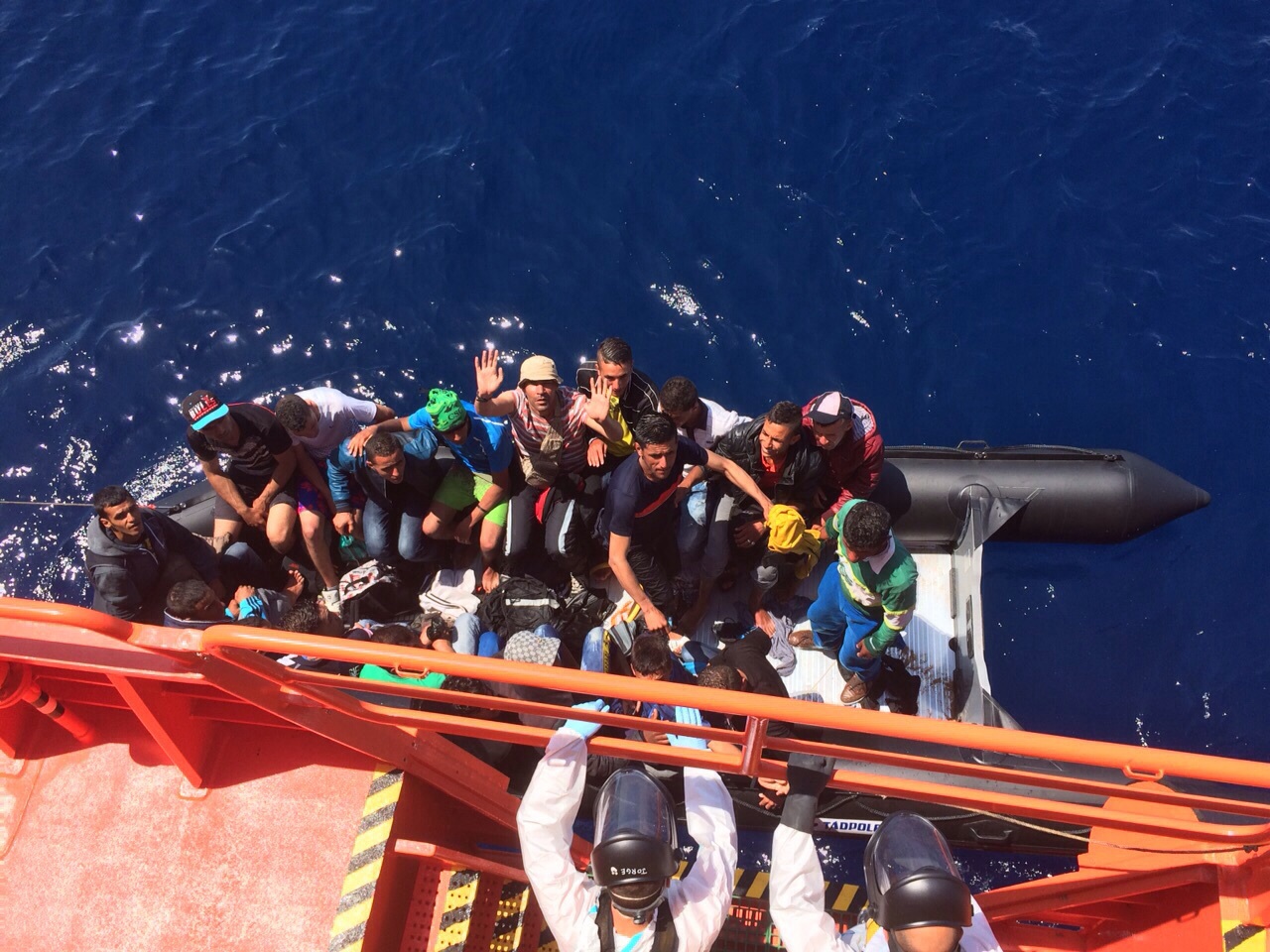 tripulantes de patera siendo rescatados por tripulantes de sasemar