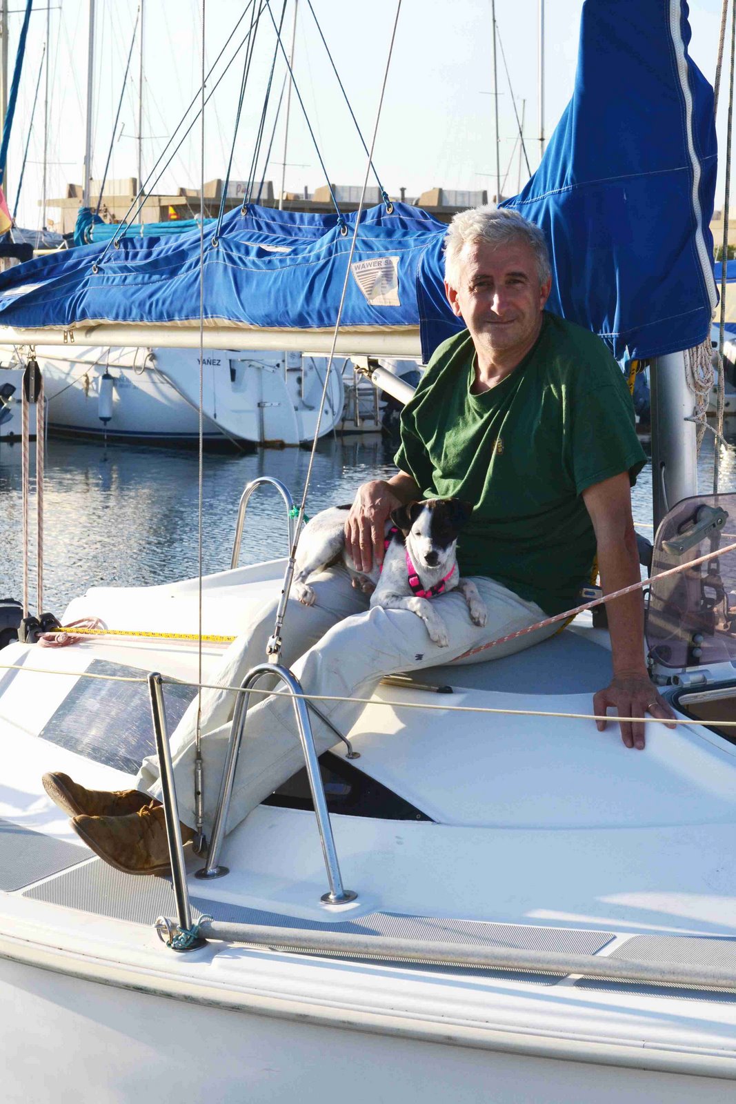 Individuo posando junto a su perro en la embarcación
