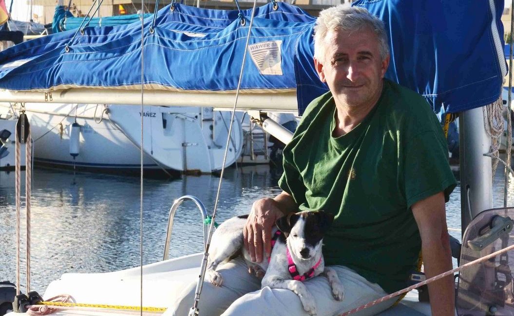Individuo posando junto a su perro en la embarcación