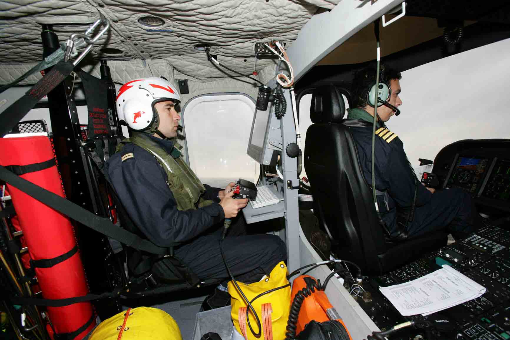 Piloto de helicóptero a los mandos y tripulante