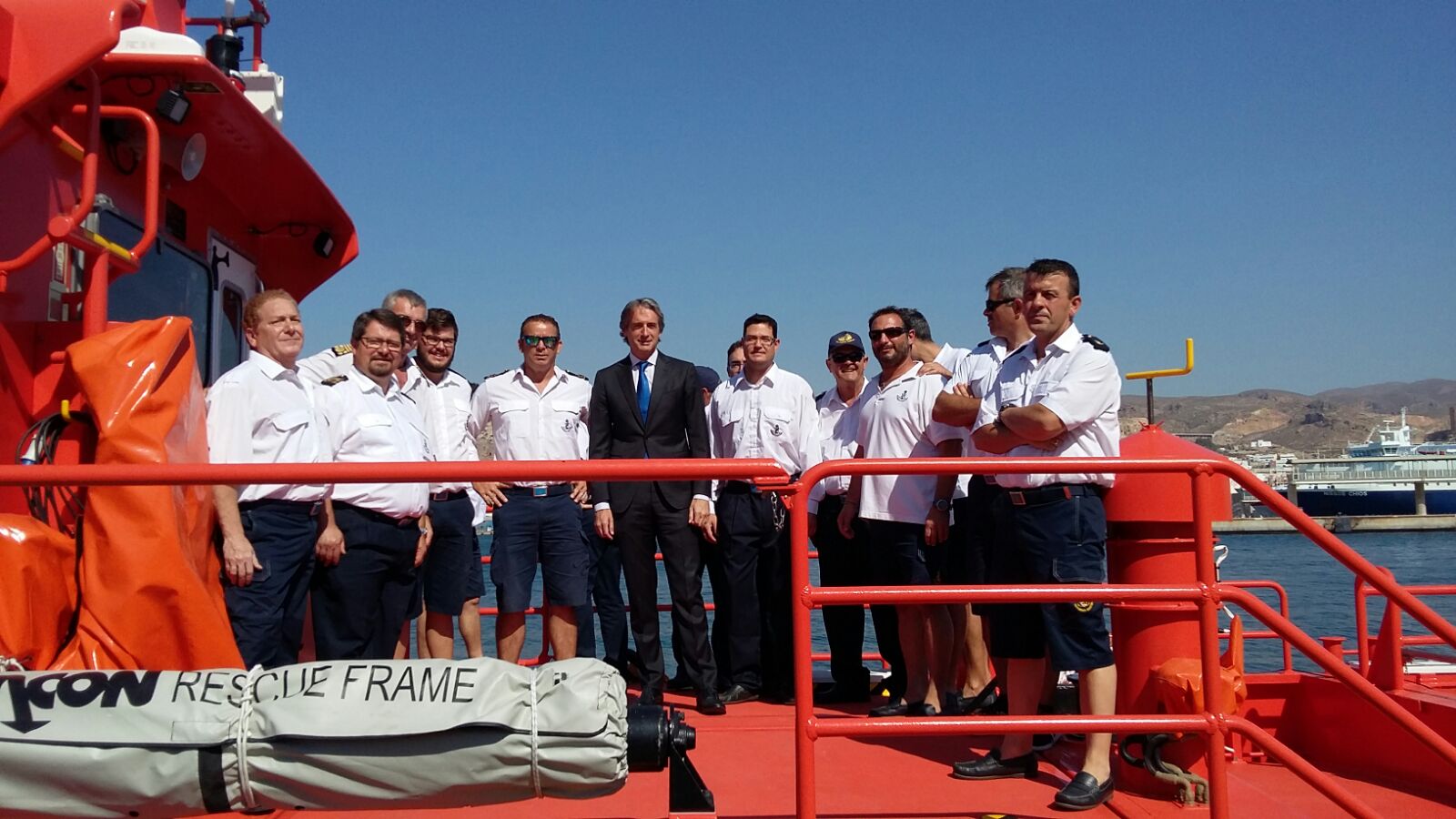 tripulación posando junto al directivo en una embarcación de salvamento marítimo