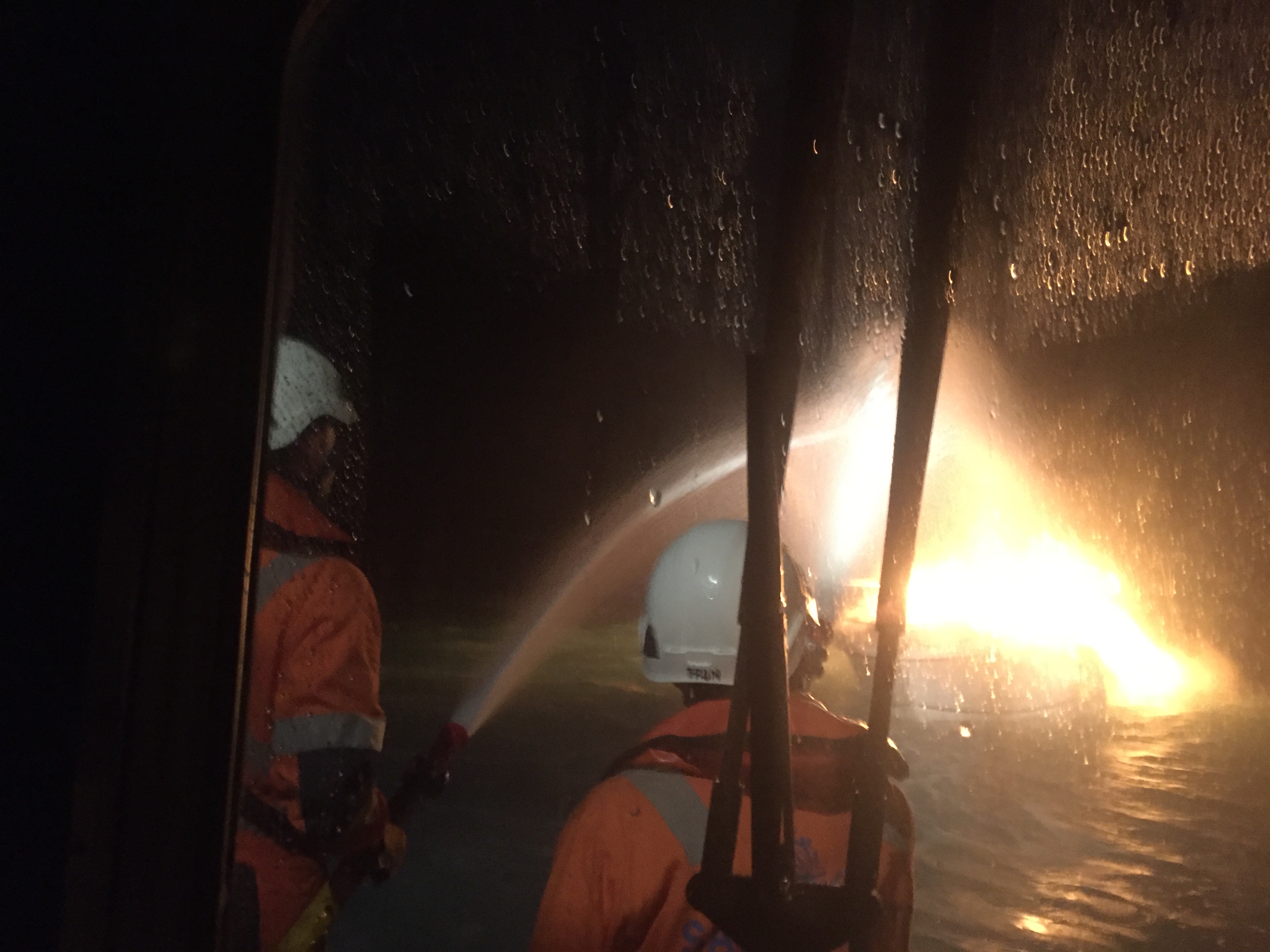 imagen de dos tripulantes de sasemar extinguiendo incendio en un barco