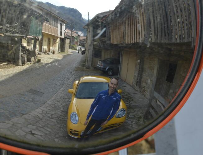 foto del reflejo de un espejo de tráfico de un hombre de mediana edad junto a su coche