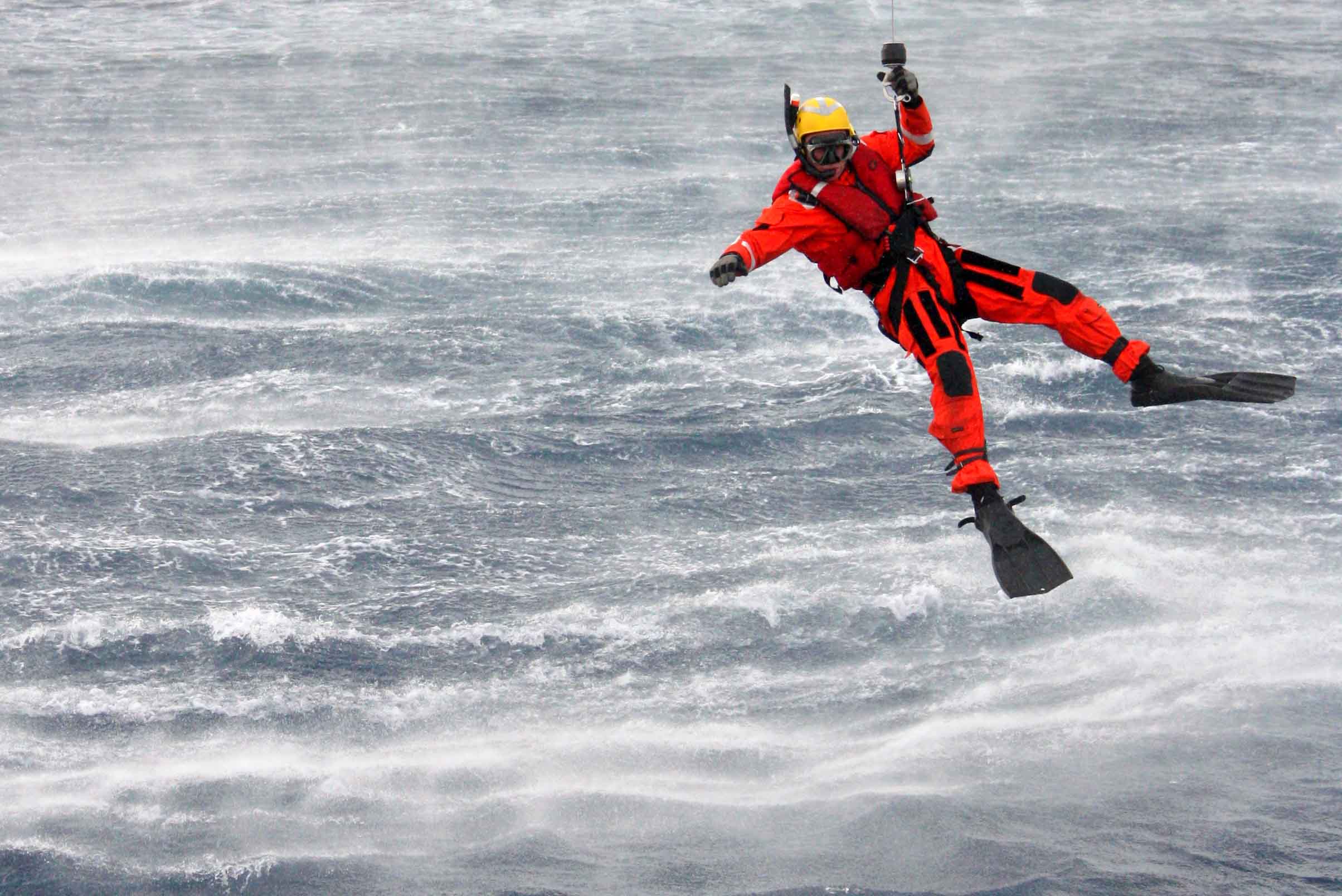 rescatador bajando al mar desde helicóptero