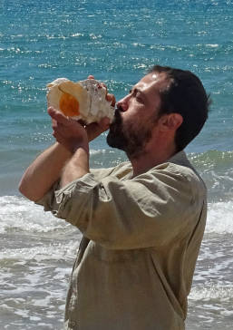 imagen de hombre soplando por una concha de mar