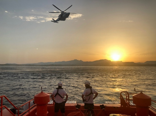 Tripulación en barco de salvamento Marítimo viendo volar un helicóptero