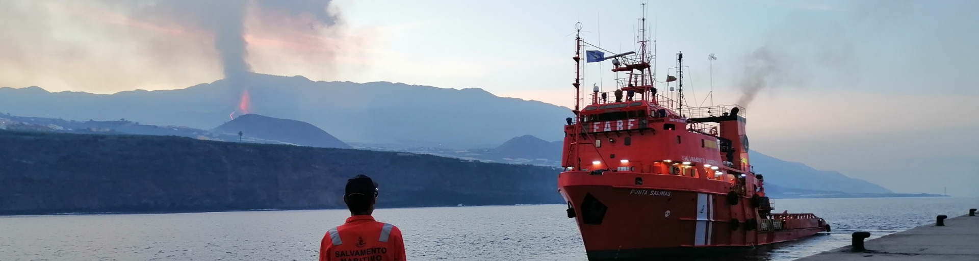 Marinero de Salvamento Marítimo busca  observa de espaldas  el volcán de la Palma