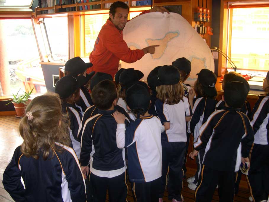 Grupo de escolares, de espaldas, observando un mapa de Tenerife